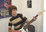 Bild: Junge spielt stehend E-Gitarre